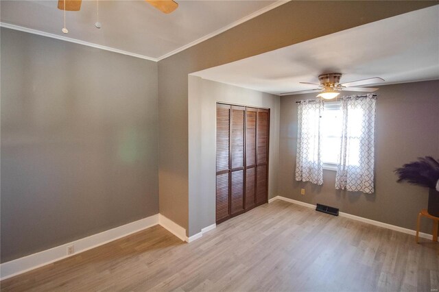 unfurnished bedroom with crown molding, baseboards, and wood finished floors