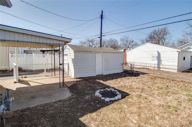 view of yard with a gate, a storage unit, an outbuilding, and fence