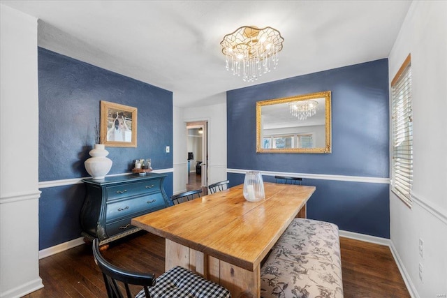 dining room with dark wood finished floors, baseboards, and a chandelier