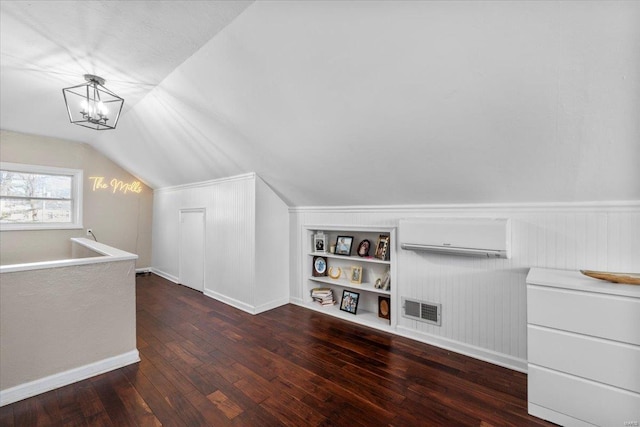 bonus room featuring visible vents, a wall mounted AC, built in features, wood-type flooring, and lofted ceiling