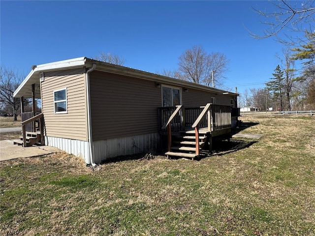 view of side of property featuring a lawn and a deck