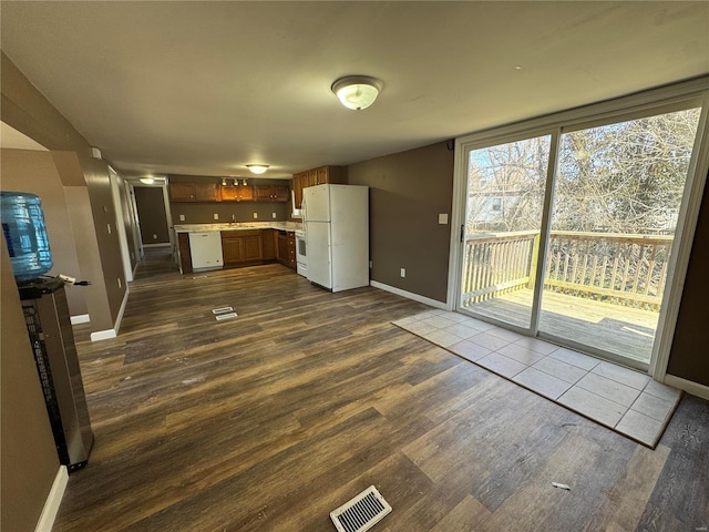 kitchen with visible vents, dark wood-type flooring, white appliances, light countertops, and baseboards