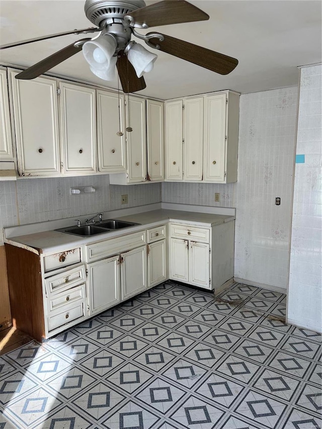 kitchen with ceiling fan, light floors, light countertops, white cabinets, and a sink