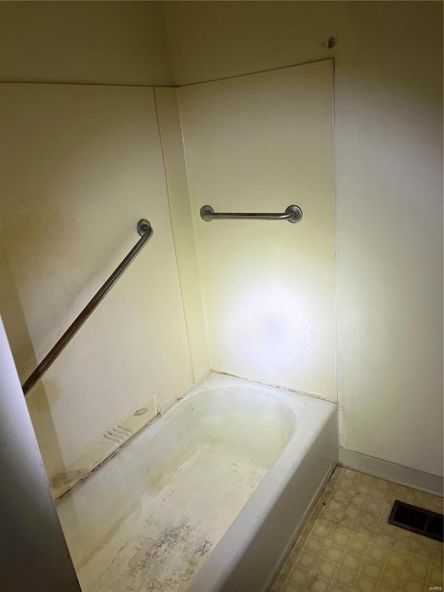 bathroom with tile patterned floors, a tub to relax in, and visible vents