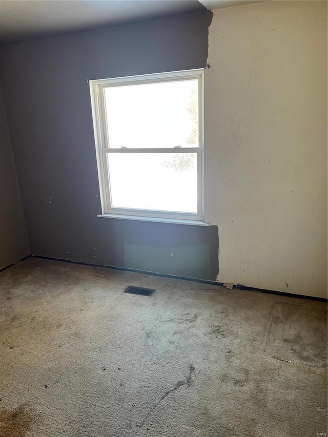 unfurnished room with carpet and visible vents