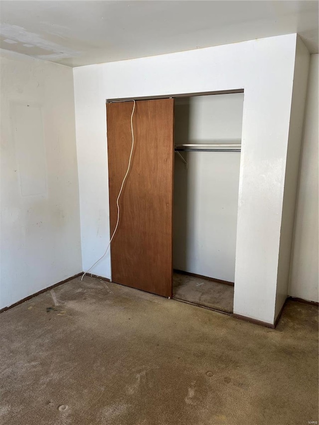 unfurnished bedroom featuring carpet and a closet