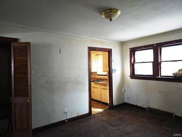 spare room featuring visible vents, baseboards, and ornamental molding