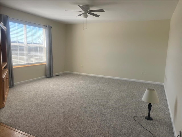 unfurnished room featuring carpet flooring, baseboards, and ceiling fan