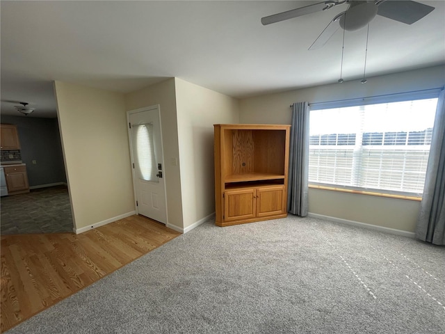 entrance foyer featuring ceiling fan, baseboards, and carpet