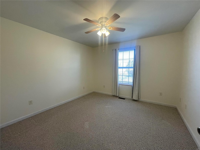 unfurnished room featuring visible vents, a ceiling fan, and baseboards