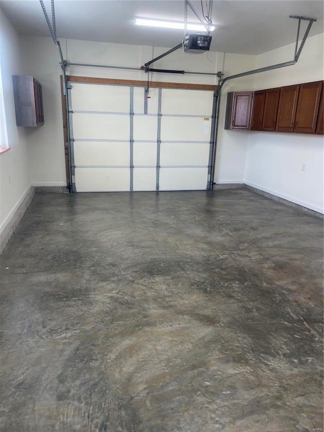 garage featuring a garage door opener and baseboards