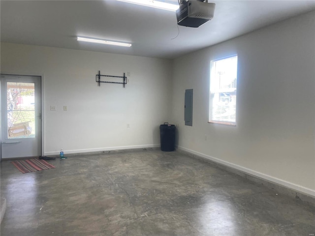 garage with electric panel, a garage door opener, and baseboards