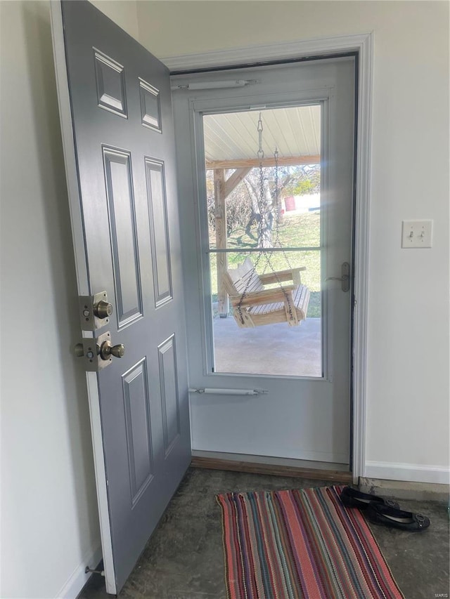 entryway featuring concrete floors and baseboards