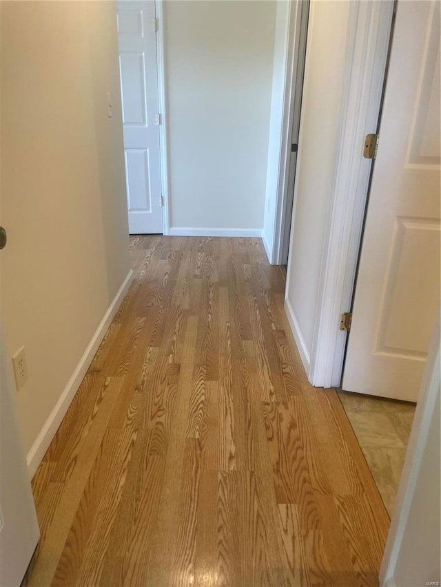 hallway with wood finished floors and baseboards