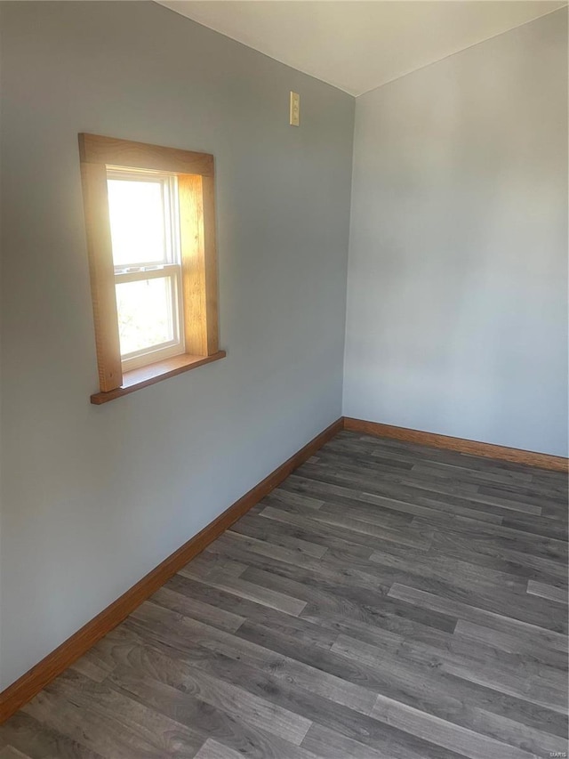 empty room featuring baseboards and dark wood-style flooring