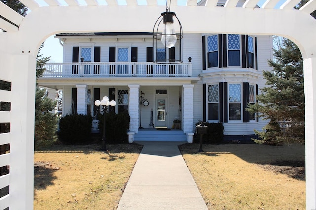 view of front of property with covered porch and a balcony