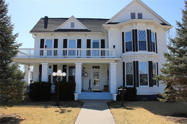 view of front of house with a balcony, covered porch, and roof with shingles