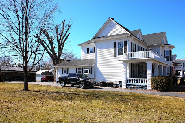 view of front of house featuring a front lawn and a balcony