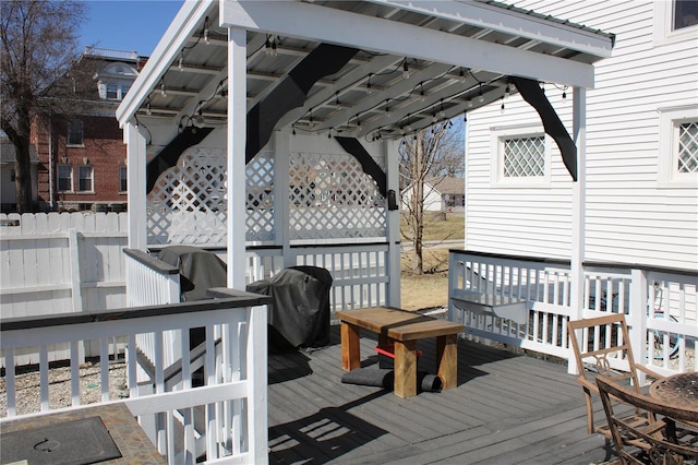 wooden terrace featuring a grill and fence