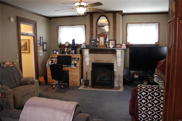 carpeted living area with crown molding, a brick fireplace, and a ceiling fan