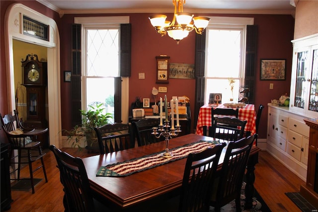 dining space featuring a notable chandelier, wood finished floors, and ornamental molding