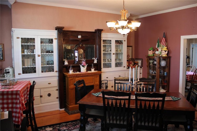 dining space with a notable chandelier, wood finished floors, and ornamental molding