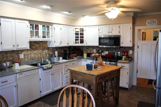 kitchen featuring a sink, decorative backsplash, ornamental molding, white cabinets, and stainless steel appliances