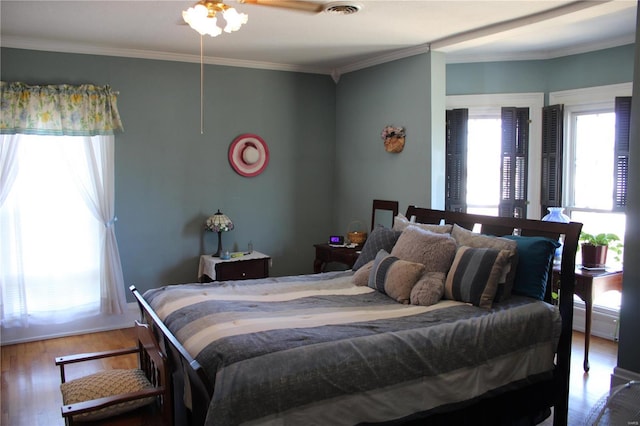 bedroom with visible vents, ornamental molding, and wood finished floors