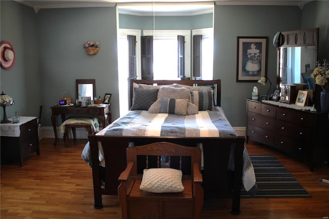 bedroom featuring wood finished floors, baseboards, and ornamental molding