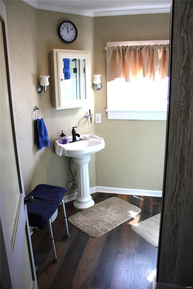 bathroom with ornamental molding, baseboards, a textured wall, and hardwood / wood-style floors