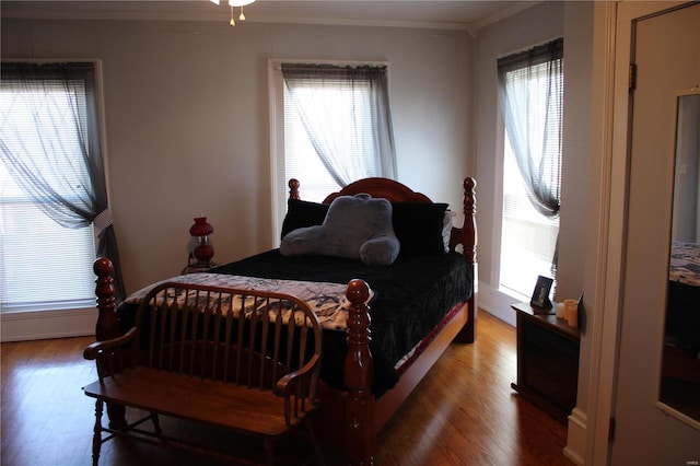 bedroom featuring crown molding and wood finished floors