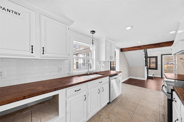 kitchen featuring decorative backsplash, wooden counters, stainless steel appliances, and a sink