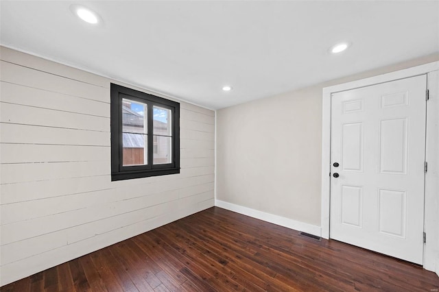 spare room with recessed lighting, visible vents, and dark wood finished floors