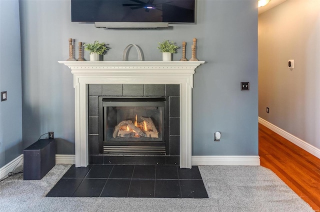 interior details with baseboards and a tile fireplace