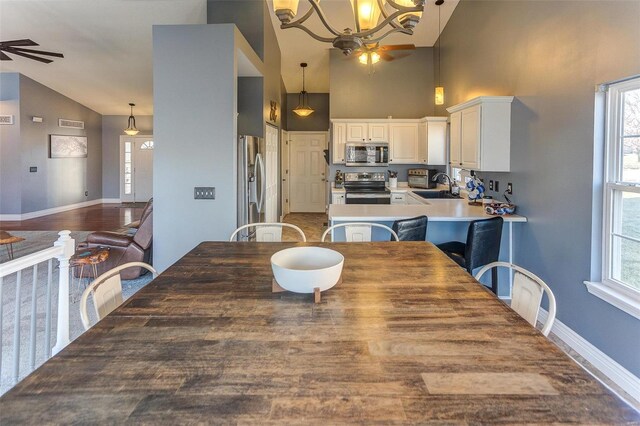 dining room featuring high vaulted ceiling, plenty of natural light, baseboards, and ceiling fan