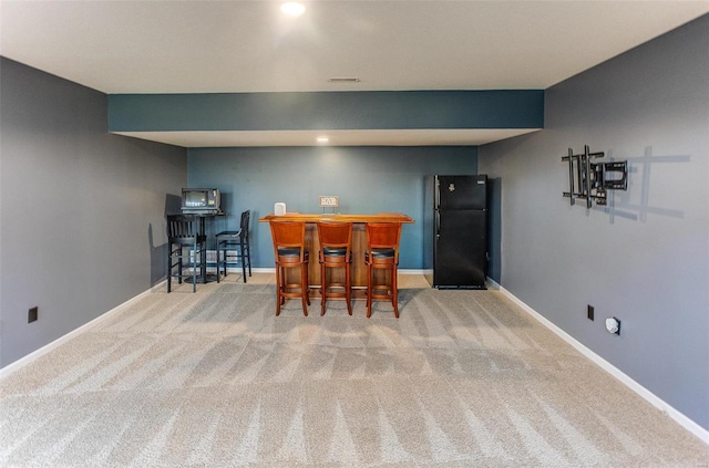 dining room featuring a bar, visible vents, baseboards, and carpet floors