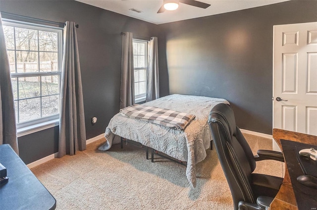 carpeted bedroom featuring a ceiling fan, visible vents, and baseboards