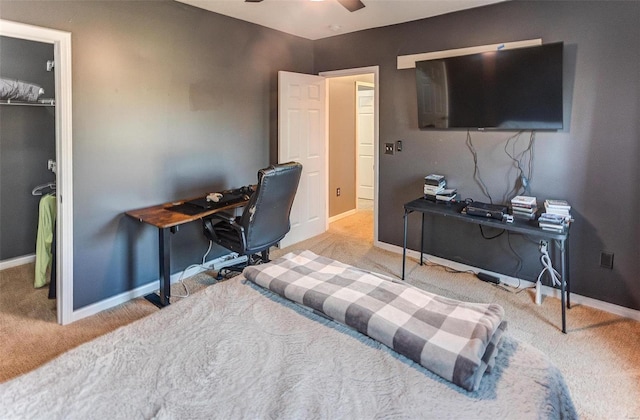 carpeted office space featuring baseboards and ceiling fan