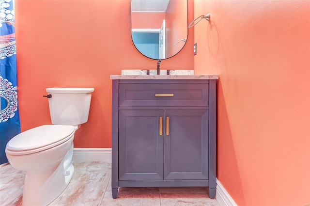 full bathroom featuring toilet, vanity, and baseboards