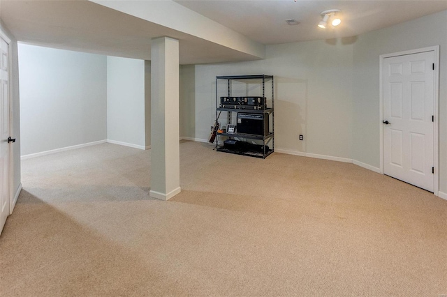 finished basement featuring baseboards and light carpet