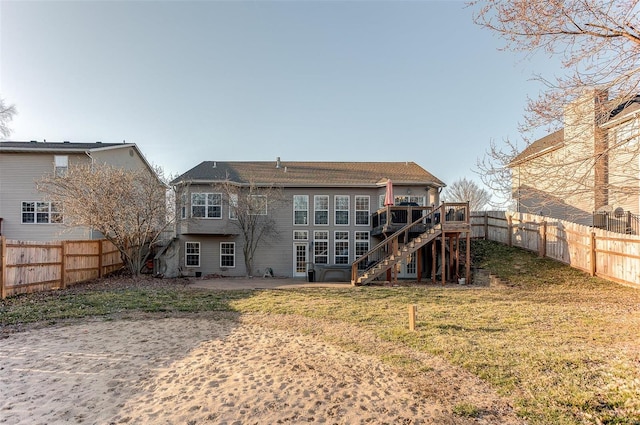 rear view of house featuring a patio, a lawn, a fenced backyard, and stairs