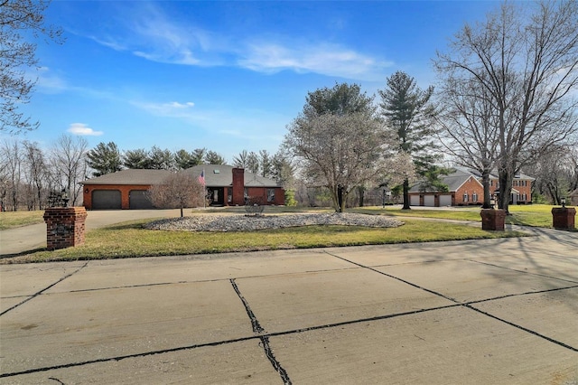 view of front of house with brick siding, a garage, concrete driveway, and a front lawn