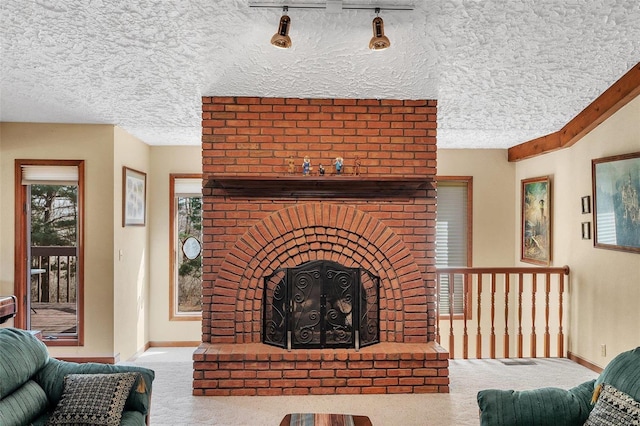 living room with baseboards, a fireplace, a textured ceiling, and carpet