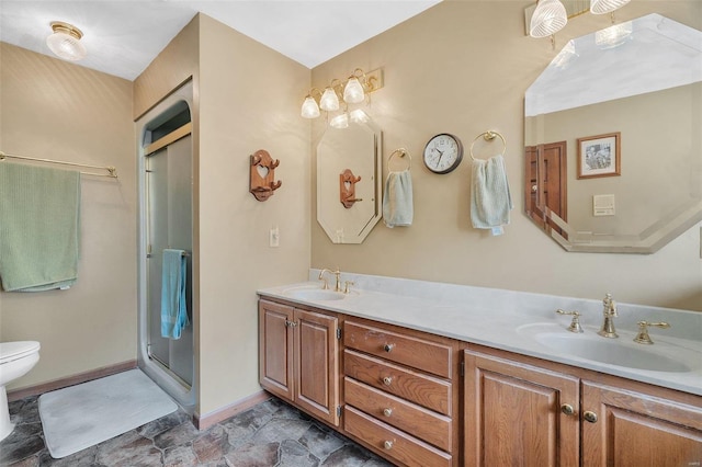 full bathroom with double vanity, a shower stall, toilet, and a sink