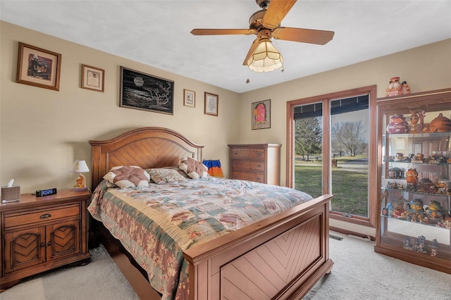 bedroom featuring multiple windows, a ceiling fan, and light carpet