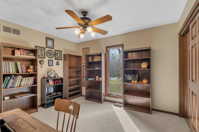 sitting room featuring visible vents, light carpet, baseboards, and a ceiling fan