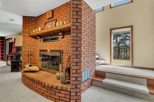 carpeted living area with visible vents, a brick fireplace, and baseboards