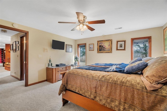 bedroom featuring visible vents, light colored carpet, a ceiling fan, and baseboards