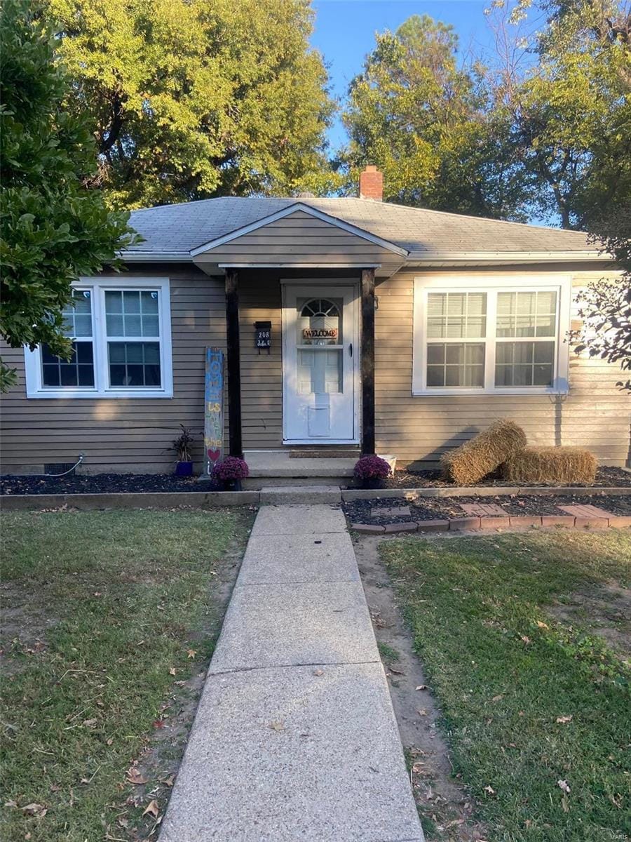 view of front of home featuring a front yard and a chimney