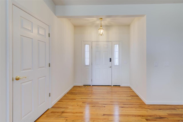 foyer entrance with baseboards and light wood finished floors